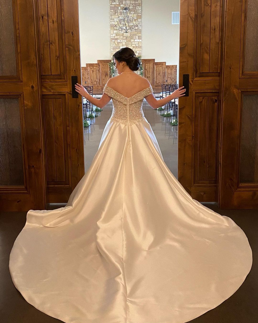 A bride in a white dress standing in front of a door.