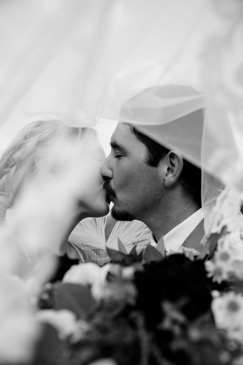 A man and woman kissing under the veil.
